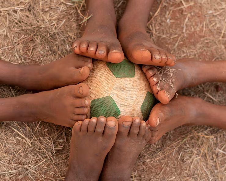 Bare feet around a worn football