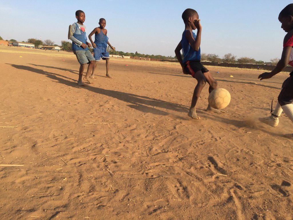 Kids playing barefoot football